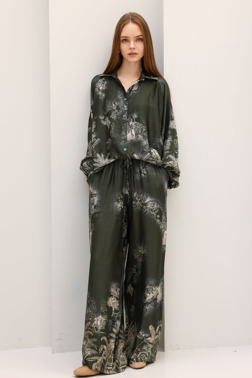 Woman wearing a dark floral pajama set against a white background