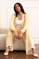Woman wearing a yellow outfit sitting on a white couch.