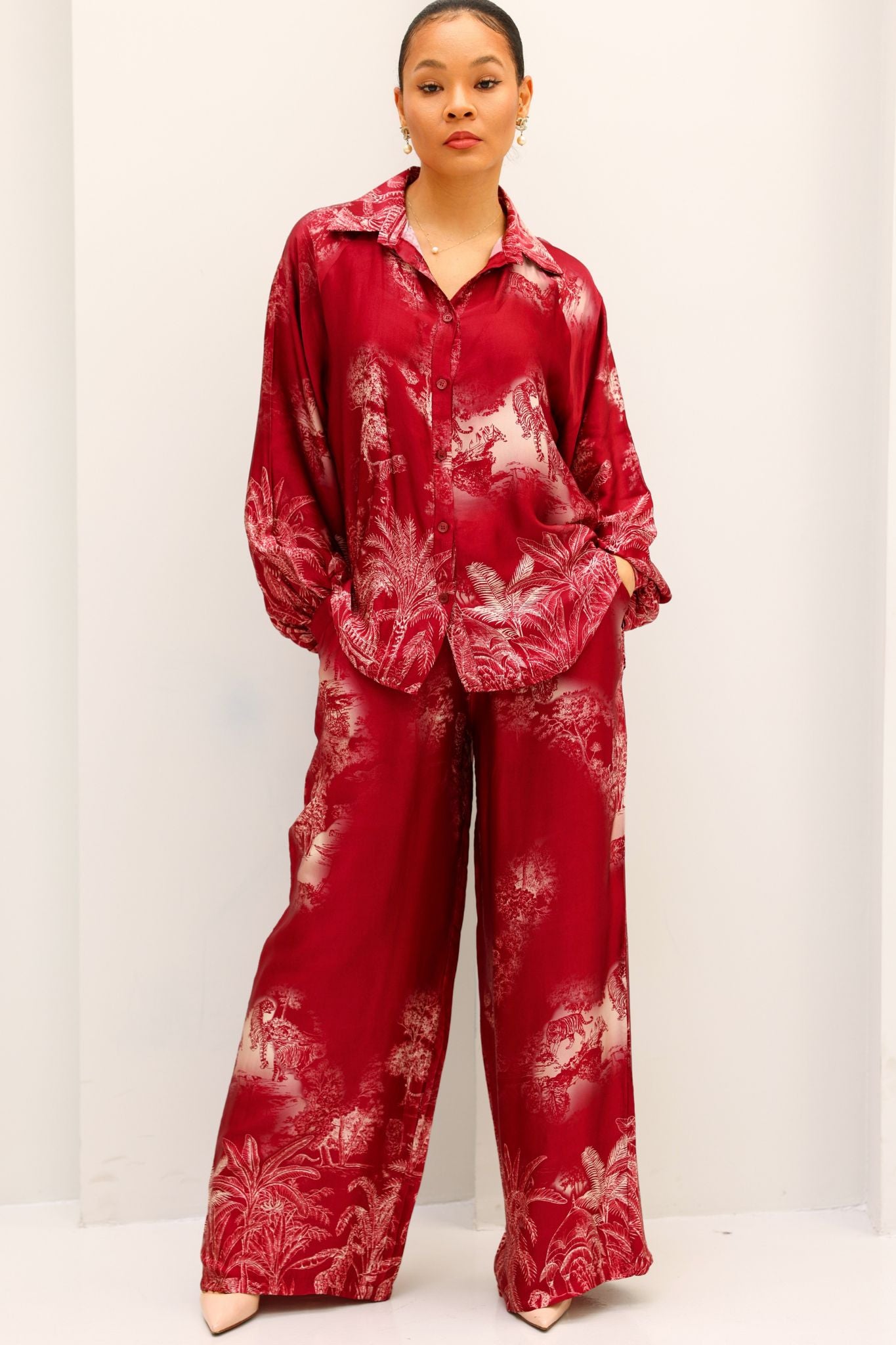 Person wearing a red tie-dye outfit on a white background