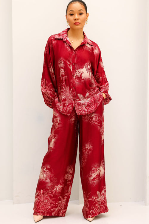 Person wearing a red tie-dye outfit on a white background