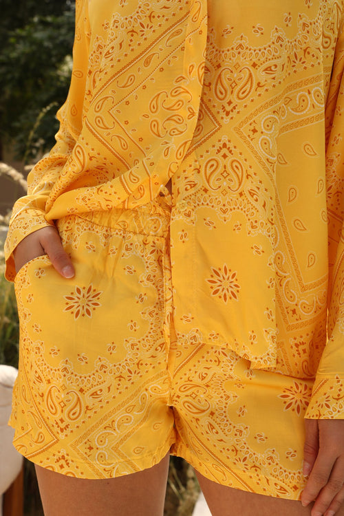 Yellow patterned outfit with a focus on the fabric texture.