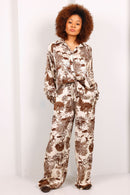 Woman wearing a patterned pajama set against a white background
