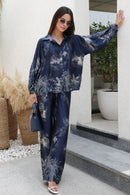 Woman wearing a blue floral outfit standing outdoors.