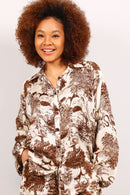 Woman wearing a patterned shirt against a plain background