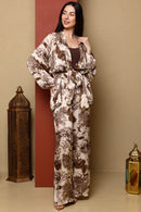 Woman wearing a patterned outfit standing against a beige wall with decorative lanterns.