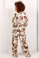 Person wearing a patterned jumpsuit on a white background