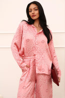 Woman wearing a pink paisley outfit against a white background