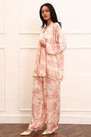 Woman wearing a pink kimono set against a white background
