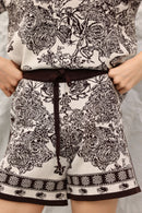 Person wearing a patterned outfit with shorts and a top.