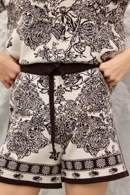 Person wearing a patterned outfit with shorts and a top.