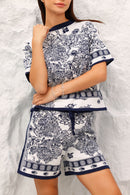 Woman wearing a navy outfit against a textured white wall