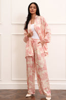 Woman wearing a pink kimono set against a white wall.