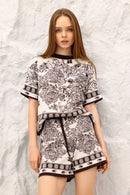 Model wearing a black and white patterned outfit against a textured white background