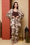 Woman wearing a patterned outfit standing in front of a beige wall with decorative lanterns.