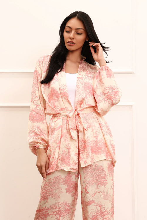 Woman wearing a pink kimono set against a white background