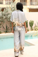 Person wearing a matching outfit with floral patterns by a poolside.