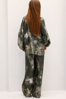 Person wearing a floral patterned outfit on a white background