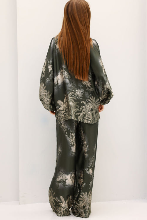 Person wearing a floral patterned outfit on a white background