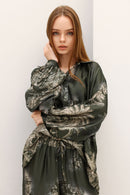 Woman wearing a green patterned dress against a white background