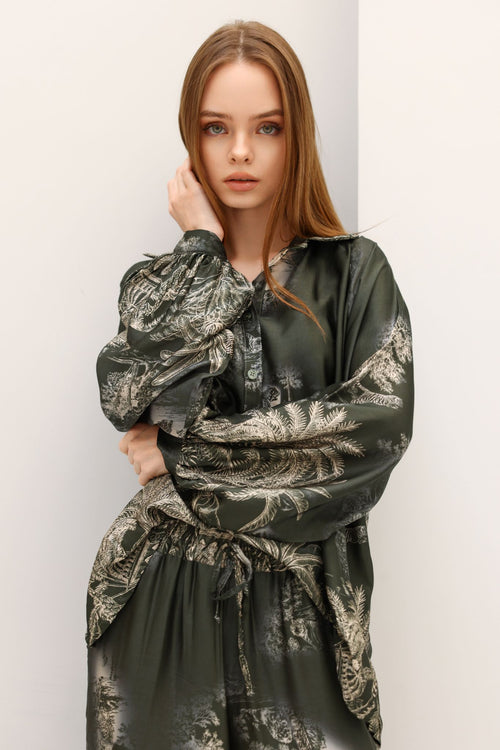 Woman wearing a green patterned dress against a white background